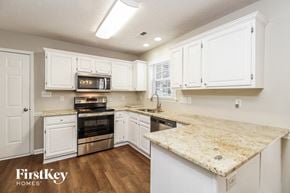 High Point house for rent - a kitchen with white cabinets and a marble counter top