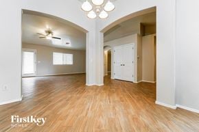 Tucson house for rent - the living room and dining room with wood flooring and a ceiling fan