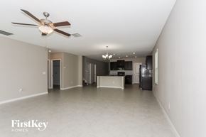 Riverview house for rent - A spacious room with a ceiling fan and a chandelier.