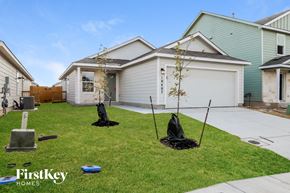 Converse house for rent - three young trees are planted in the front yard of a house
