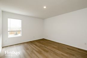 Converse house for rent - a bedroom with white walls and wooden floors and a window