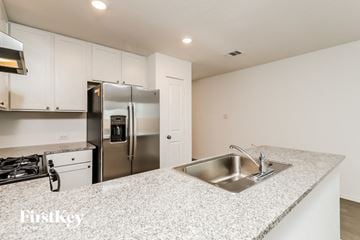 Converse house for rent - A kitchen with a stainless steel refrigerator and a granite countertop.