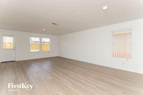 Converse house for rent - A spacious room with wooden flooring and two windows with blinds.