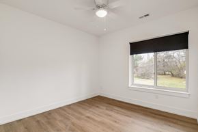 Troy apartment for rent - a bedroom with white walls and a window and wood floors