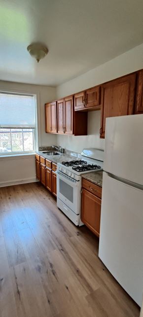 Chicago apartment for rent - a kitchen with white appliances and wooden cabinets