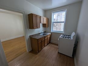 Chicago apartment for rent - A kitchen with wooden floors and white walls.