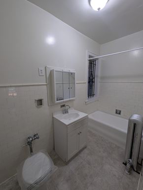 Chicago apartment for rent - A white bathroom with a toilet, sink, and bathtub.