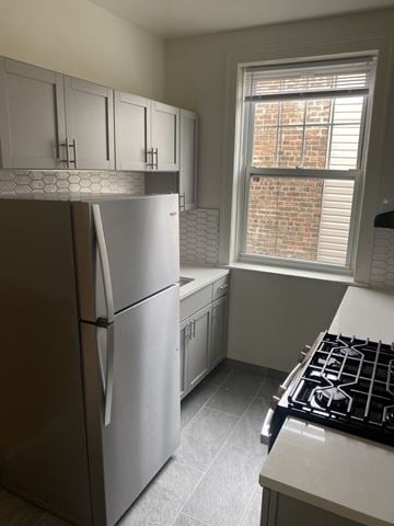 Chicago apartment for rent - A kitchen with a stainless steel refrigerator and a window with blinds.