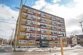 Ottawa apartment for rent - A large multi-story building with a yellow and red facade.