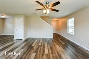 Houston house for rent - A spacious room with wooden floors and a ceiling fan.