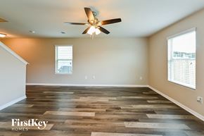 Houston house for rent - A spacious room with wooden flooring and a ceiling fan.