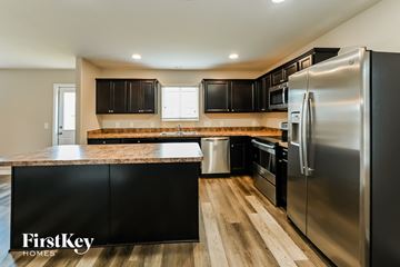 Houston house for rent - A kitchen with a stainless steel refrigerator and black cabinets.
