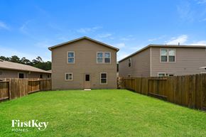 Houston house for rent - A house with a fence and a grassy yard.