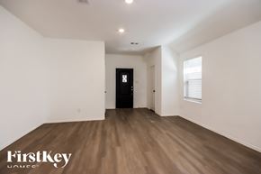 New Caney house for rent - A room with wooden flooring and a black door.
