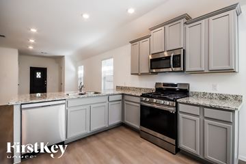 New Caney house for rent - A kitchen with a stove top oven and microwave.