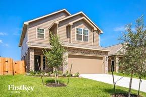 New Caney house for rent - A house with a brown garage door and a brown fence.