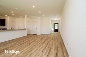New Caney house for rent - A spacious room with wooden flooring and white walls.