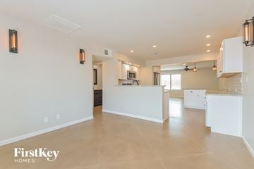Tucson house for rent - A spacious kitchen and living room with white cabinets and a large island.
