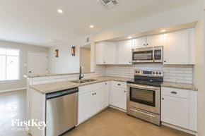 Tucson house for rent - A kitchen with white cabinets and stainless steel appliances.