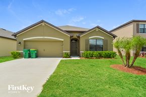 Mims house for rent - a beige house with a driveway and a lawn