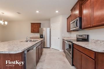 Mims house for rent - a kitchen with stainless steel appliances and marble counter tops
