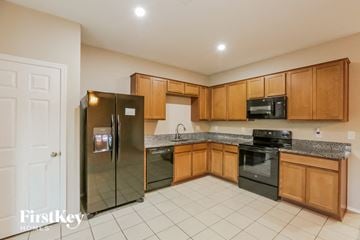 Laveen house for rent - a kitchen with wooden cabinets and stainless steel appliances