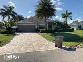 Cape Coral house for rent - A house with a driveway and a trash can in front of it.
