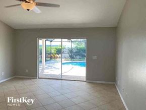 Cape Coral house for rent - A room with a sliding glass door leading to a pool.