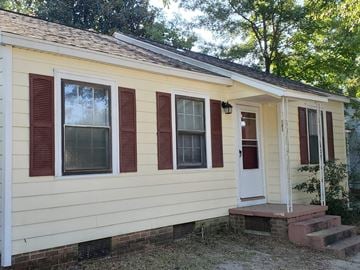 Hattiesburg house for rent - A small house with a red door and red shutters.