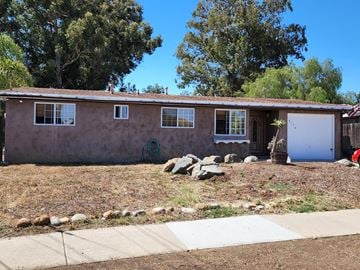 San Diego house for rent - A house with a brown stucco exterior and a white garage door.