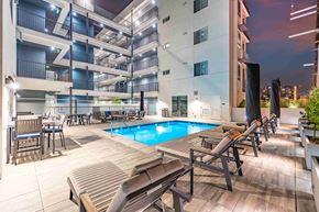 Los Angeles apartment for rent - a swimming pool in front of an apartment building at night