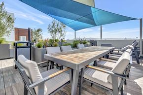 Los Angeles apartment for rent - a dining area with a table and chairs under an umbrella