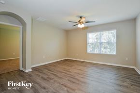 Leesburg house for rent - A spacious room with a ceiling fan and wooden flooring.