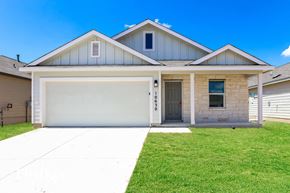 Converse house for rent - a white house with a garage door and a lawn