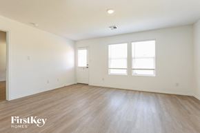 Converse house for rent - an empty living room with white walls and wood floors