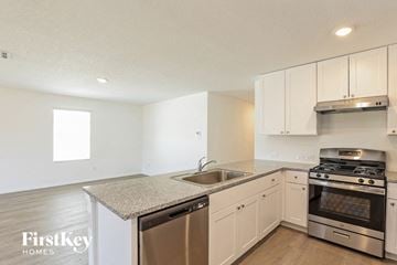Converse house for rent - a kitchen with white cabinets and stainless steel appliances