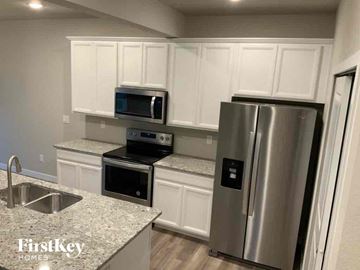 Colorado Springs house for rent - a kitchen with white cabinets and a stainless steel refrigerator