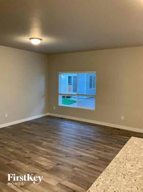Colorado Springs house for rent - an empty living room with a window and wood floors