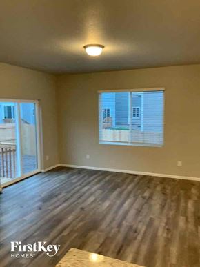 Colorado Springs house for rent - an empty living room with wooden floors and a window