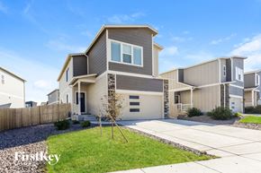 Colorado Springs house for rent - a beige and gray house with a driveway and lawn