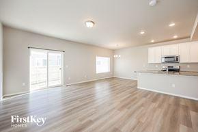 Colorado Springs house for rent - the living room and kitchen of an empty house with wood flooring