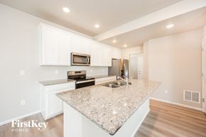 Colorado Springs house for rent - a kitchen with white cabinets and a granite counter top