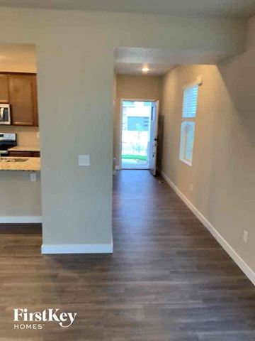 Colorado Springs house for rent - a hallway with a hard wood floor and a door to a kitchen
