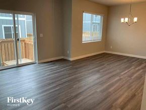 Colorado Springs house for rent - an empty living room with wood floors and a balcony