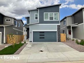 Colorado Springs house for rent - a blue house with a driveway in front of it