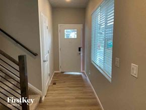 Colorado Springs house for rent - a hallway with a staircase and a door to a room with a window