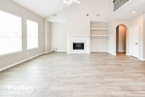 Houston house for rent - A spacious living room with a fireplace and a balcony.