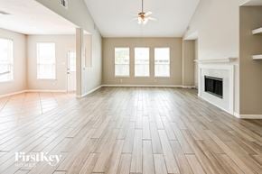 Houston house for rent - A spacious room with wooden flooring and a fireplace.