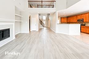 Houston house for rent - A spacious living room with wooden flooring and a fireplace.