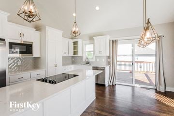 Parkville house for rent - a kitchen with white cabinets and stainless steel appliances and a balcony